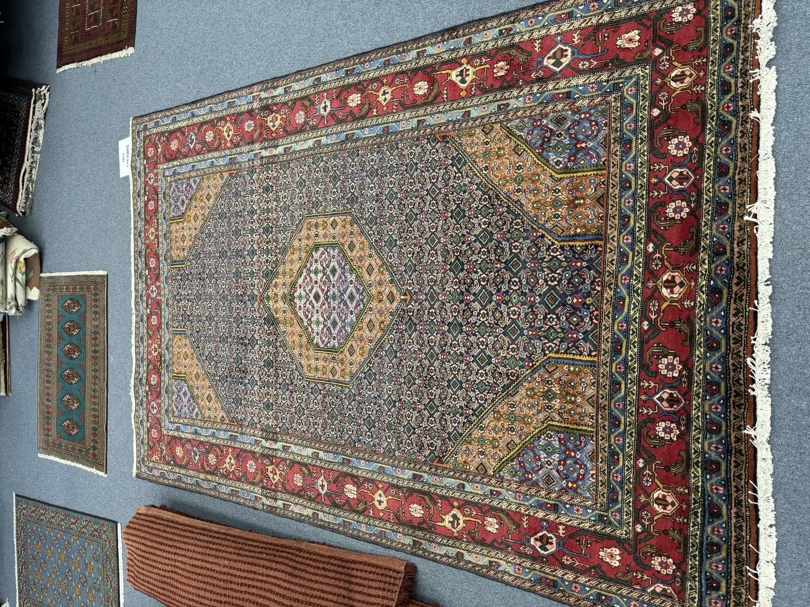 Detailed handmade Persian rug displayed on the showroom floor