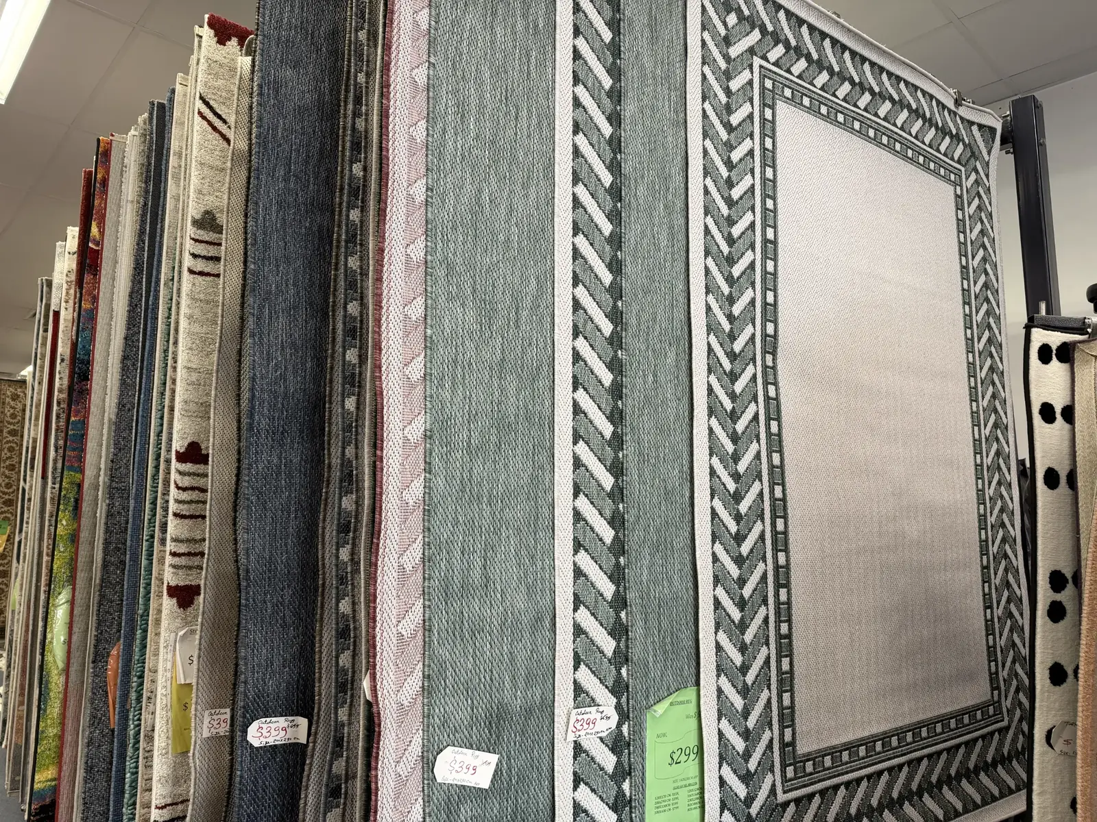 Indoor and outdoor rugs displayed vertically in the showroom