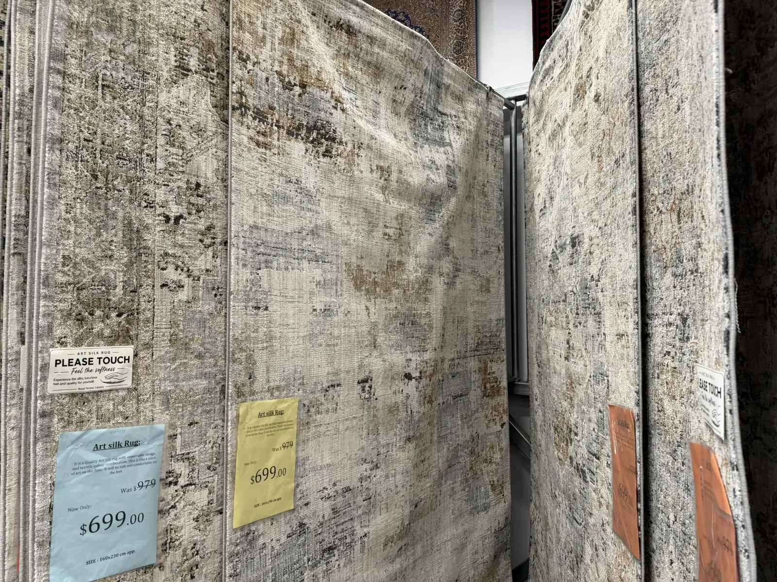 Modern neutral rugs hanging in the Royal Persian Carpets showroom